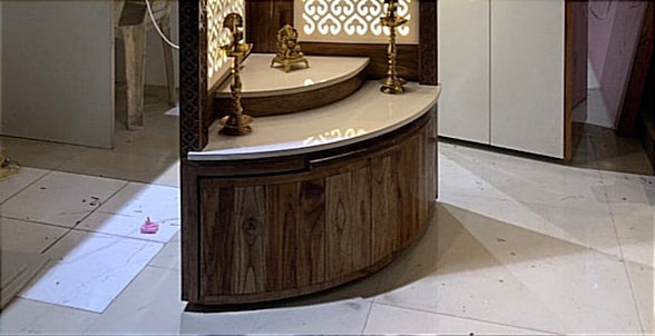 Modern Pooja Mandir with curved wooden storage cabinet and marble countertop, perfect for organizing prayer essentials and accessories.