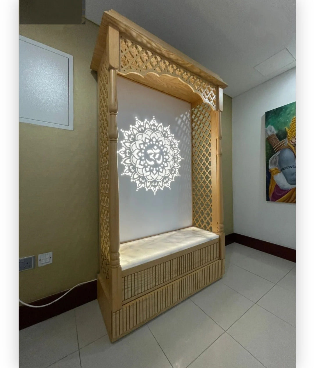 Premium wooden Pooja mandir with backlit Om motif and marble seating, combining traditional design with modern lighting.