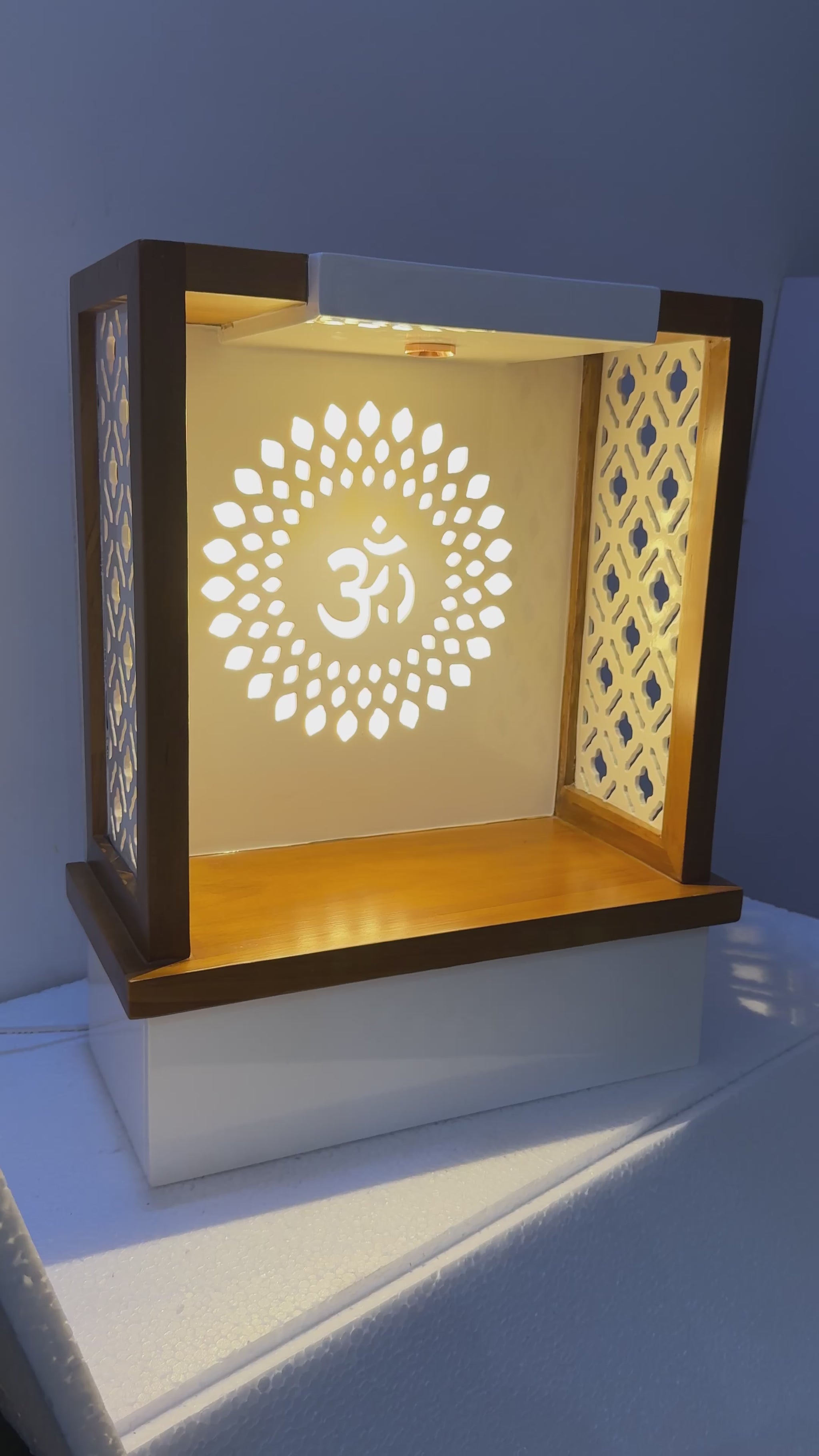 Sleek pooja unit combining contemporary aesthetics with traditional elements like patterned panels and warm LED lighting.