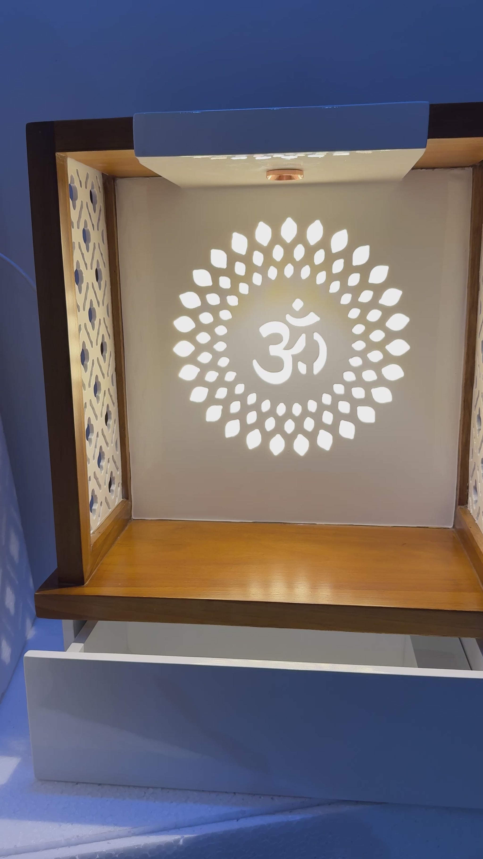 Premium wooden mandir featuring a radiant Om motif, fine lattice paneling, and a functional drawer for incense, diya, and accessories.