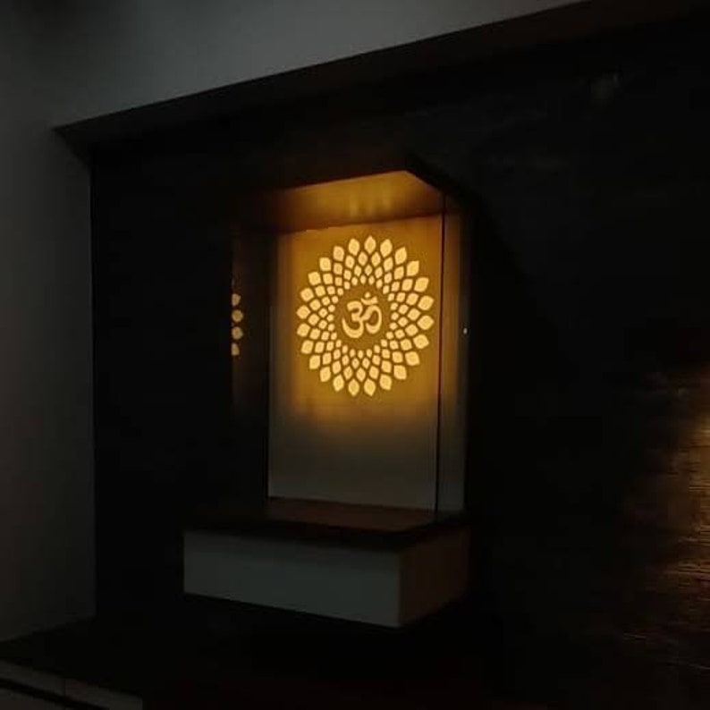Stylish white and brown pooja mandir featuring a spacious drawer and decorative Om cutwork for a divine touch.