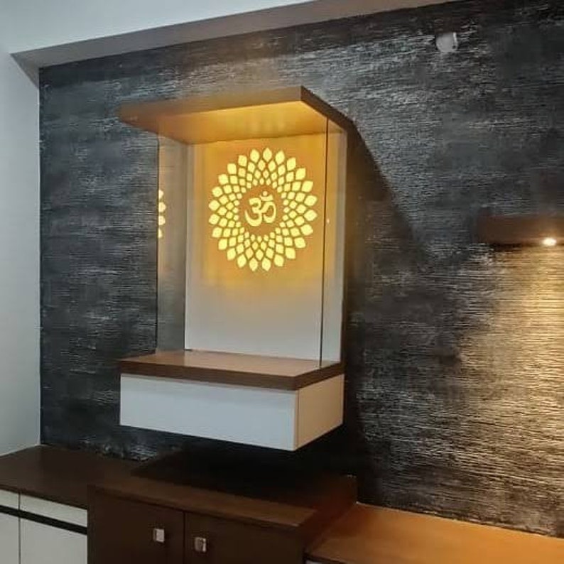 A stylish, modern wooden pooja unit with glowing Om design and a pull-out drawer for essentials.